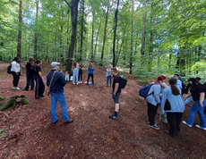 Gruppenfoto der Schüler*innen mit Lehrperson im kühlen Wald