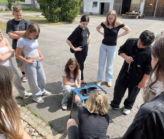Schüler*innen probieren das Melken aus